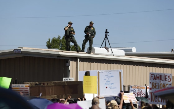 Image: U.S. Border Patrol agents watch as they take photos and video of the crowd protesting outside the U.S. Immigration and Customs Enforcement processing center in El Paso