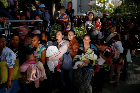 Image: Women carrying babies wait as they try to buy diapers outside a pharmacy in Caracas, March 18, 2017.