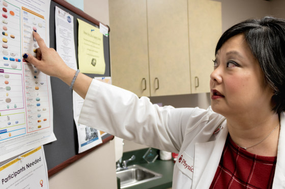 Dr. Michelle Salvaggio, medical director of the Infectious Diseases Institute at the University of Oklahoma Health Sciences Center in Oklahoma City, points to drugs used to treat HIV/AIDS. Medical advancements since the epidemic surfaced in the 1980s have helped many of her HIV-positive patients lead healthy lives.