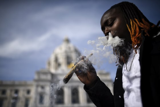 Image: A man smokes an oversized joint