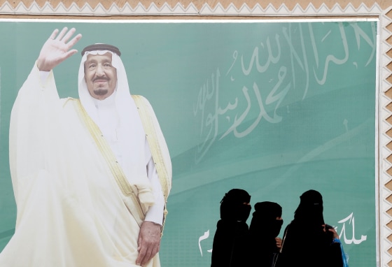 Image: FILE PHOTO: Women walk past a poster of Saudi Arabia's King Salman bin Abdulaziz Al Saud during Janadriyah Cultural Festival on the outskirts of Riyadh
