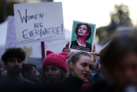 Image: An demonstrator holds a photo of Brazilian activist Marielle Franco during an International Women's Day rally in Los Angeles on March 8, 2019.