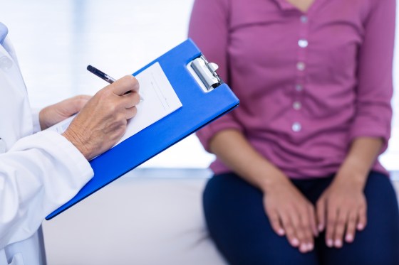 Doctor writing on clipboard in clinic