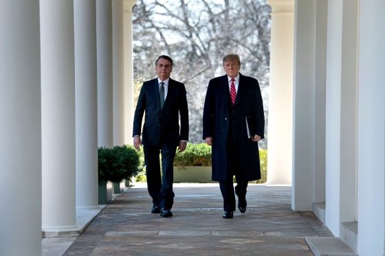Image: Brazil's President Jair Bolsonaro and President Donald Trump walk to a press conference in the Rose Garden on March 19, 2019.