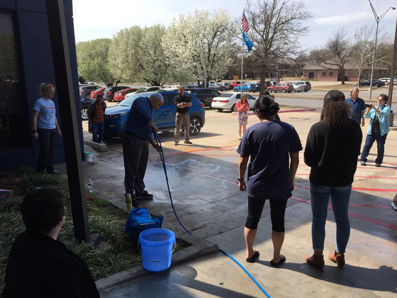 Community members help to power wash and clean swastikas and other racist graffiti found at Oklahoma City Democratic Party headquarters and Chickasaw Nation's Oklahoma City area office, on Thursday.