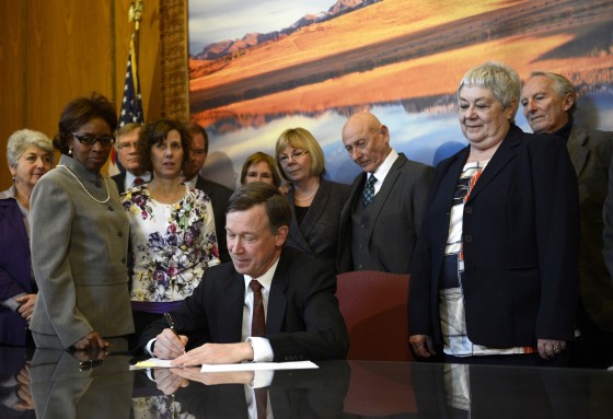 Image: Colorado Governor John Hickenlooper signs a gun control bill at the state capitol in Denver on March 20, 2013.