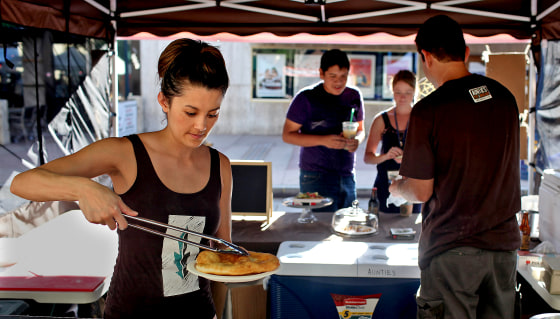 Kate Koyama, co-owner of Auntie's Native American Fry Bread, left, prepares a fry bread taco as co-