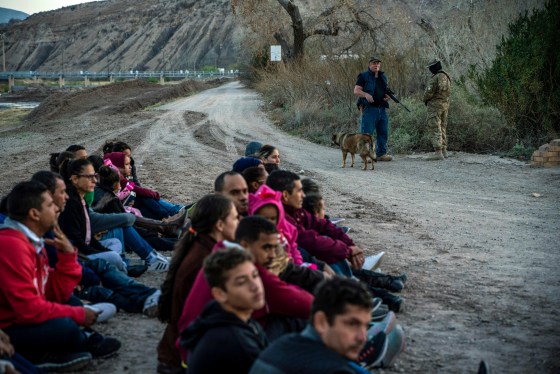 Image: Jeff Allen, a property owner, stands with a Constitutional Patriots militia member near a group of Brazilian migrants who just crossed the into the United States from Mexico in Sunland Park, on March 20, 2019.