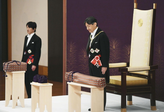 Image: Japan's Emperor Naruhito, flanked by Crown Prince Akishino, attends a ritual called Kenji-to-Shokei-no-gi, a ceremony for inheriting the imperial regalia and seals, at the Imperial Palace in Tokyo