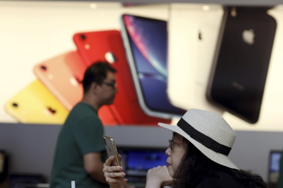 Image: A customer looks at her iPhone in a store of U.S. tech company Apple in Beijing