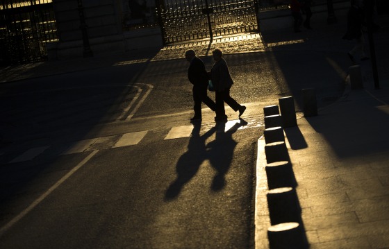 Image: An elderly couple walks near the Royal Palace in Madrid on April 4, 2017.