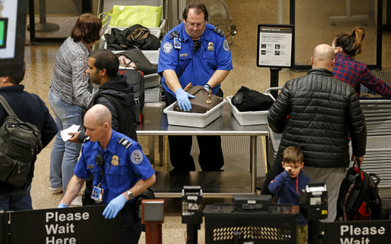 Image: A TSA agent helps passengers at Salt Lake City International Airport on Jan 16. 2019.