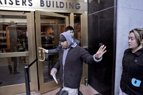 Hay Hov waves to supporters as he and his wife, Catherine Depooter-Hov, enter the U.S. Immigration and Customs Enforcement offices in San Francisco where he turned himself over to ICE officials, on March 13, 2019.
