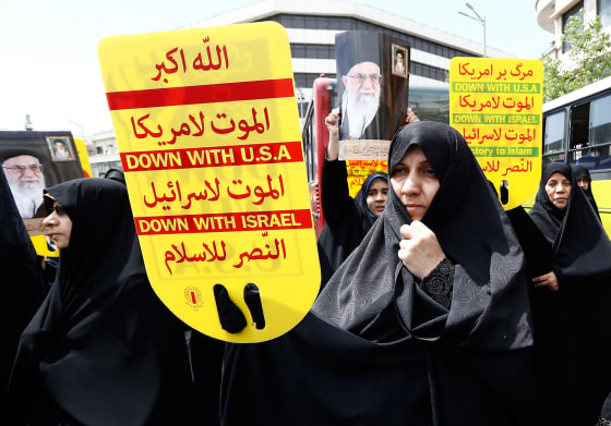 Image: Demonstrators hold signs and portraits of Iran's Supreme Leader Ayatollah Ali Khamenei as they chant anti-U.S. slogans during a rally in Tehran