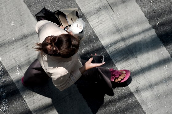 Image: A woman walks while on her smartphone in Bangkok, Thailand, in 2013.