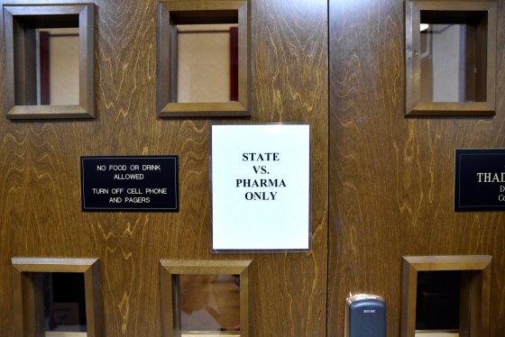 Image: A sign is seen on the outside of the courtroom on the first day of a trial of Johnson & Johnson and Teva Pharmaceutical Industries in Norman