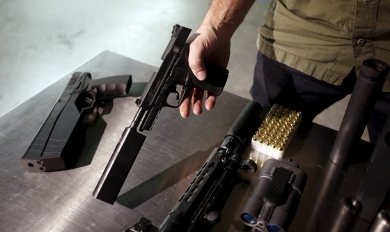 Image: SilencerCo CEO Joshua Waldron shows guns with suppressors in West Valley City