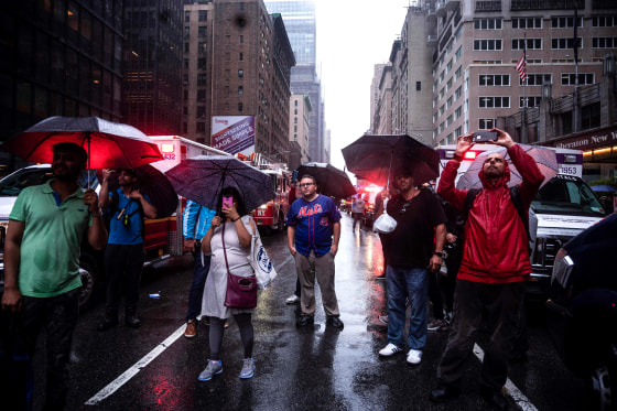 Image: Onlookers watch the scene after a helicopter crashed on top of a building in Midtown Manhattan on June 10, 2019.