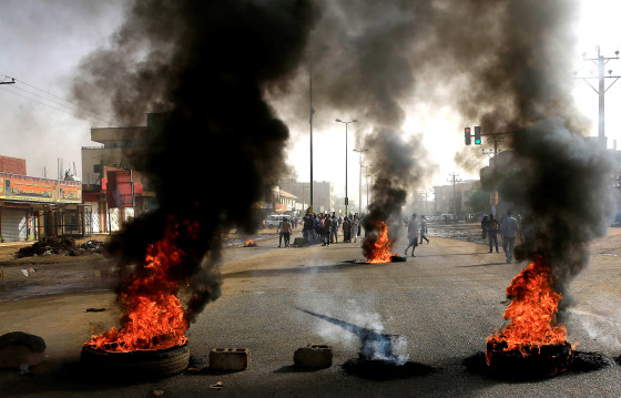 Image: Sudanese protesters use burning tyres to erect a barricade on a street, demanding that the country's Transitional Military Council hand over power to civilians, in Khartoum