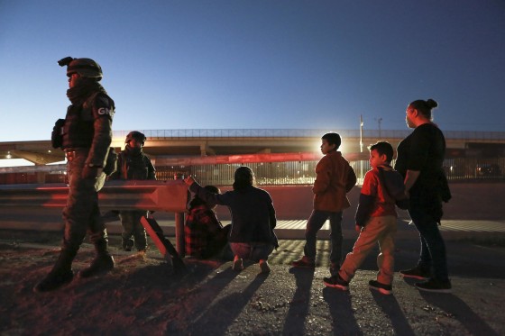 Image: Military police wearing the insignia of the new National Guard detain migrants from Guatemala to keep them from crossing the Rio Grande from Ciudad Juarez, Mexico to El Paso, Texas