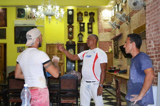 David Diaz, owner of Havana bed and breakfast "Casa David y Lidia Diaz," meets with carpenters who specialize in restoring colonial homes.