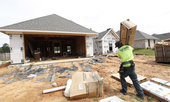A worker carries supplies for a new house in Brandon, Mississippi, on June 19, 2019.