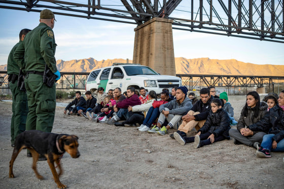 Image: A group of about 30 Brazilian migrants, who had just crossed the border, sit on the ground near US Border Patrol agents, on the property of Jeff Allen, who used to run a brick factory near Mt. Christo Rey on the US-Mexico border in Sunland Park, Ne