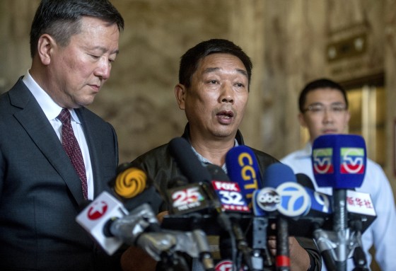 Ronggao Zhang, middle, father of murdered University of Illinois visiting scholar Yingying Zhang, speaks to the media in Chinese as attorney Zhidong Wang, left, translates during a news conference, Thursday, July 18, 2019, at the U.S. Federal Courthouse in Peoria, Ill. In background is Yingying's boyfriend Xiaolin Hou.