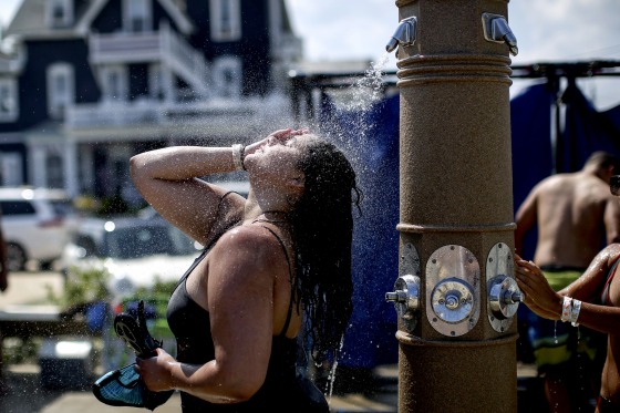 Image: A woman washes off on the beach in Ocean Grove, New Jersey, on July 20, 2019. Many areas of the United States were under excessive heat watches as temperatures soared to record levels.