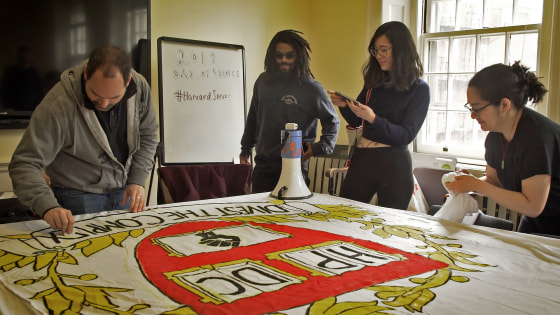 Members of the Harvard Prison Divestment Campaign paint signs before interrupting a freshman dinning hall with chants and banner drops.