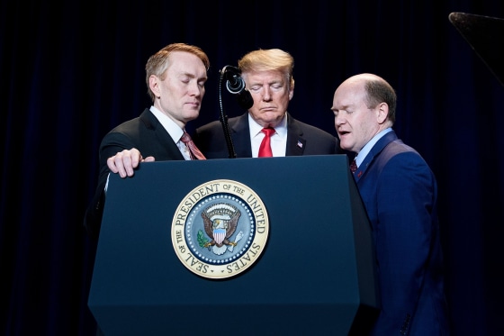 Image: Sen. James Lankford, President Donald Trump and Sen. Christopher Coons pray during the National Prayer Breakfast in Washington on Feb. 7, 2019.