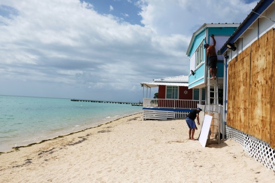 Image: A man boards up the windows of a beach house in the tourist zone of El Combate as Tropical Storm Dorian approaches in Cabo Rojo