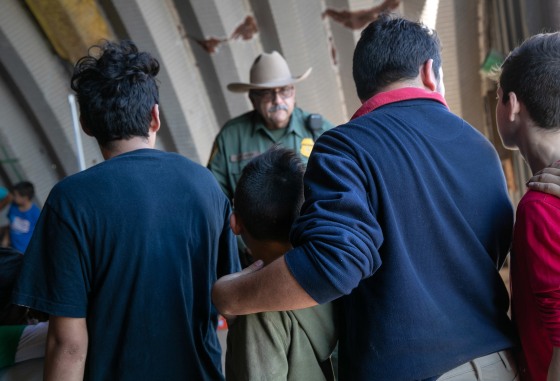 Image: A U.S. Border Patrol agent speaks with families, mostly from Central America, who had crossed the Rio Grande from Mexico and presented themselves to agents