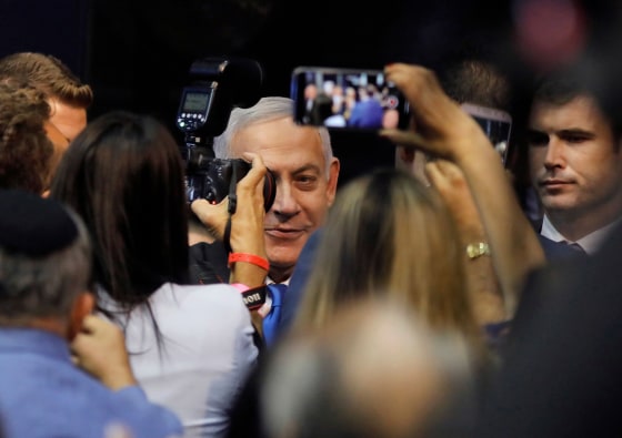 Image: Israeli Prime Minister Benjamin Netanyahu is confronted by the press as he arrives to address supporters at his Likud party's electoral campaign headquarters in the coastal city of Tel Aviv