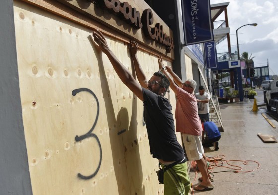 Image: People board up an Urban Cottage store in preparation for Hurricane Humberto in Hamilton, Bermuda