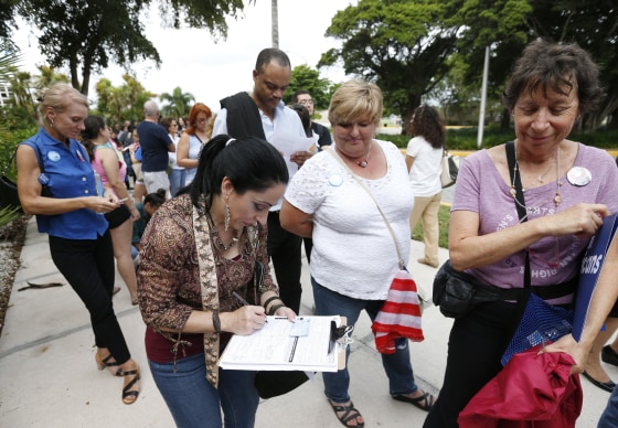 Image: A woman fills out a new voter registration form