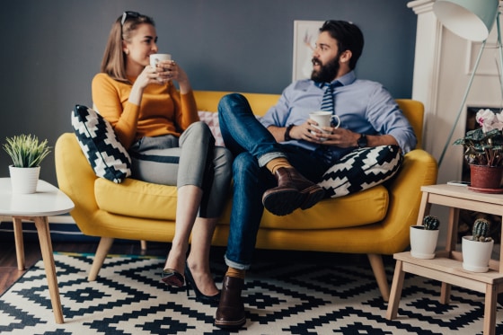 Coworkers are chatting and drinking coffee in a break room