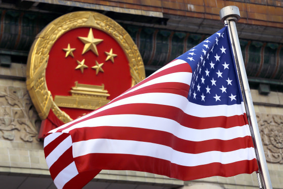 An American flag is flown next to the Chinese national emblem outside the Great Hall of the People in Beijing on Nov. 9, 2017.