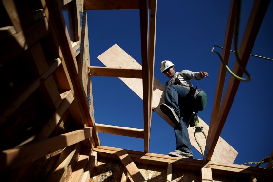 Image: A worker carries lumber while building a house in Petaluma, Calif., in 2015.