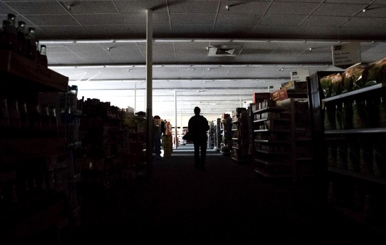 Image: Shift supervisor James Quinn walks through a darkened CVS Pharmacy in downtown Sonoma, Calif., during a power cut on Oct. 9, 2019.