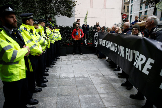 Image: Protesters hold a banner outside the BlackRock office during an Extinction Rebellion demonstration in the City of London, Britain