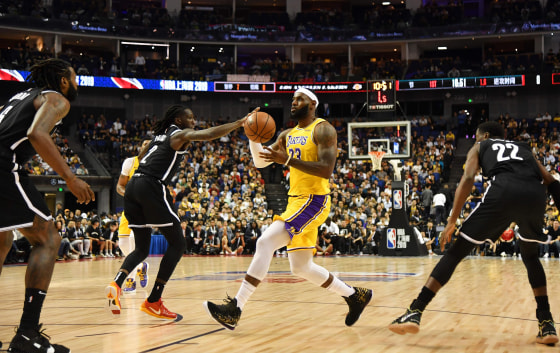 Image: LeBron James of the Los Angeles Lakers drives past Brooklyn Nets players during the National Basketball Association pre-season game between the LA Lakers and Brooklyn Nets at the Mercedes Benz Arena in Shanghai