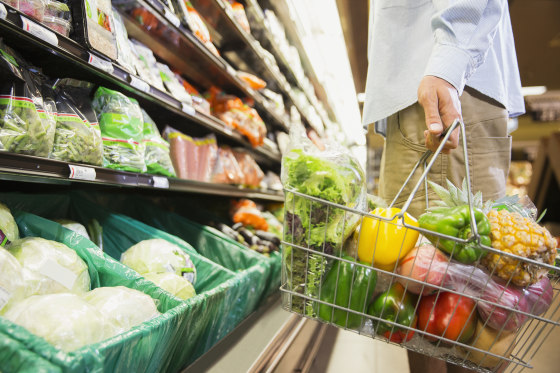 Man carrying full shopping basket in grocery store