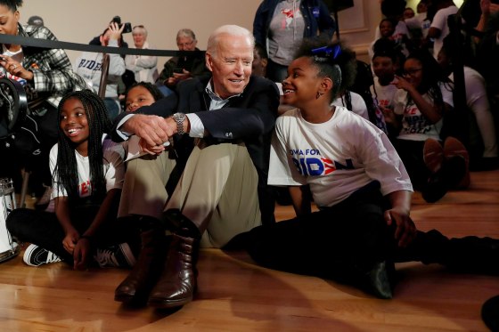 Image: Democratic 2020 presidential candidate and former Vice President Joe Biden sits with kids from the Union Baptist Crusaders drill team during an event at the Brown Derby Ballroom in Waterloo, Iowa