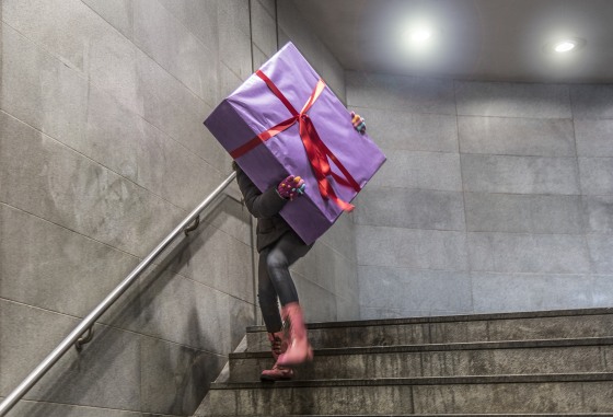 Young girl running with large gift at Christmas