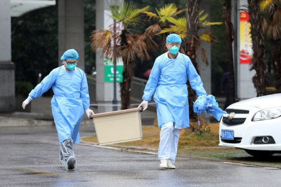 Image: Medical staff carry a box as they walk at the Jinyintan hospital, where the patients with pneumonia caused by the new strain of coronavirus are being treated, in Wuhan