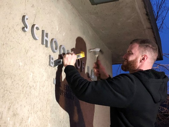 UC Berkeley carpenter Joe Poppi removes lettering saying \"Boalt Hall\" from the side of the Berkeley Law building early on Jan. 30, 2020.