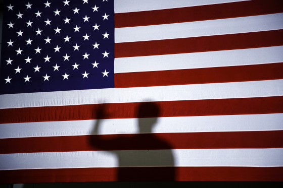 Image: Pete Buttigieg's shadow is cast on an American flag at a campaign event in Plymouth, N.H., on Feb. 10, 2020.