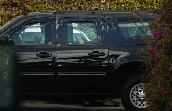 Image: President Donald Trump uses his phone as a motorcade departed his Mar-a-Lago resort in Palm Beach, Fla.