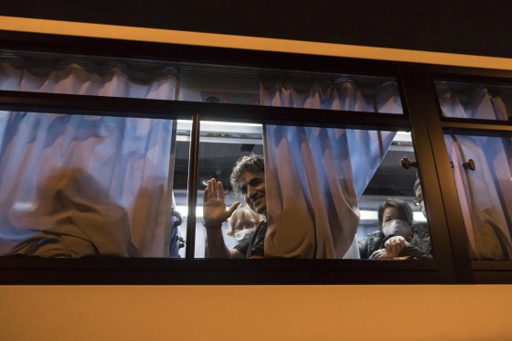 Image: An American citizen waves from a bus as he arrives at Haneda airport on Feb. 17, 2020 in Tokyo, Japan.